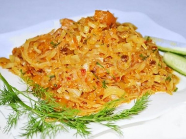 Cabbage pumpkin carrot onion stewed with tomatoes in a frying pan