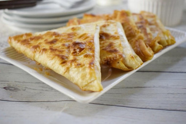 Triangles of pita bread with egg and cheese in a frying pan