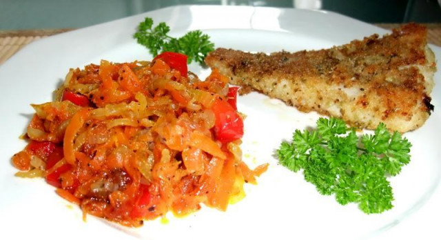 Fried carrots with onions and bell peppers in a frying pan