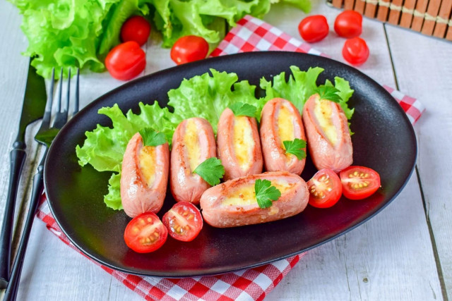 Fried sausages with cheese in a frying pan