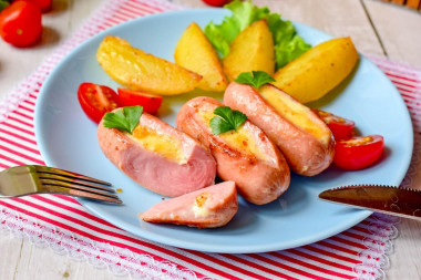 Fried sausages with cheese in a frying pan