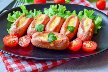 Fried sausages with cheese in a frying pan