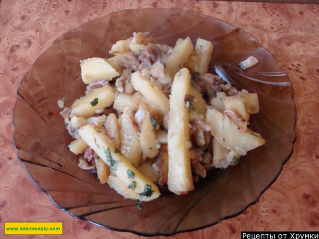 Potatoes fried in oil with onions and mushrooms