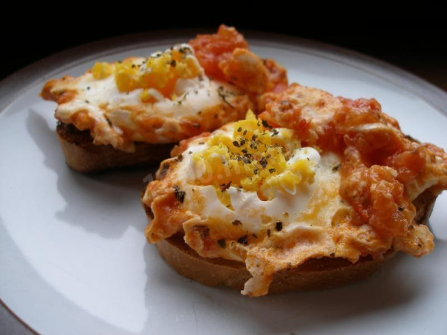 Scrambled eggs with tomatoes, garlic and parmesan