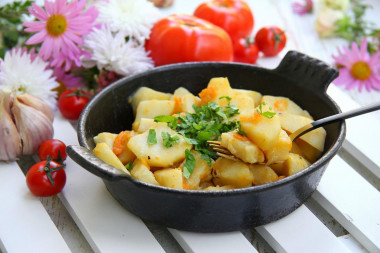 Stewed potatoes with carrots and onions in a frying pan