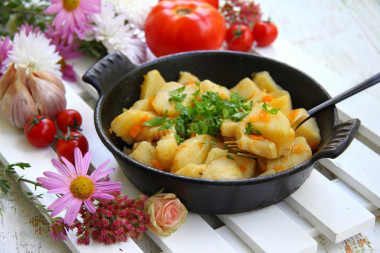 Stewed potatoes with carrots and onions in a frying pan