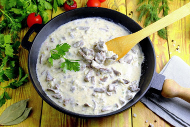 Chicken hearts in sour cream sauce in a frying pan