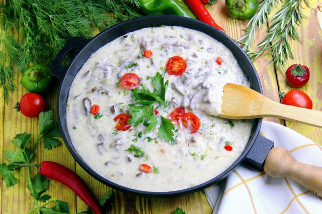 Chicken hearts in sour cream sauce in a frying pan