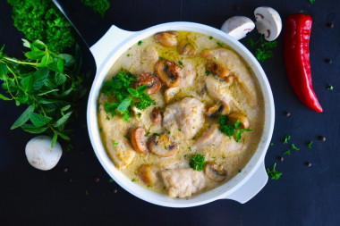 Chicken with mushrooms in sour cream sauce in a frying pan