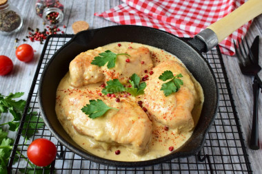 Chicken in cream sauce with cheese in a frying pan