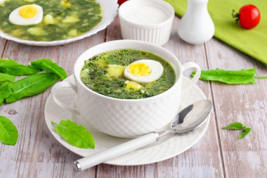 Green cabbage soup with nettle and sorrel with egg