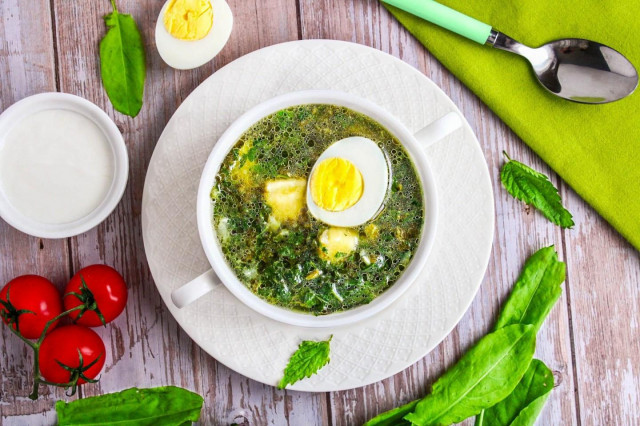 Green cabbage soup with nettle and sorrel with egg