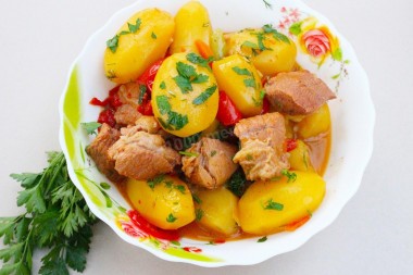 Stewed vegetables in a cauldron over a fire with meat