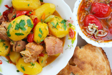 Stewed vegetables in a cauldron over a fire with meat