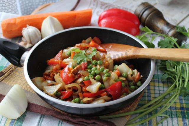 Stewed cabbage peppers onions carrots in a frying pan