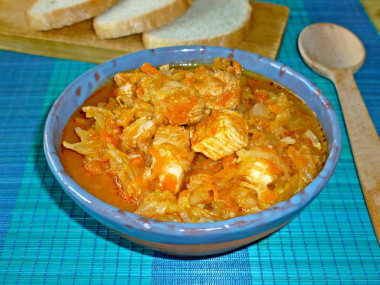 Stewed cabbage with chicken and carrots in a saucepan