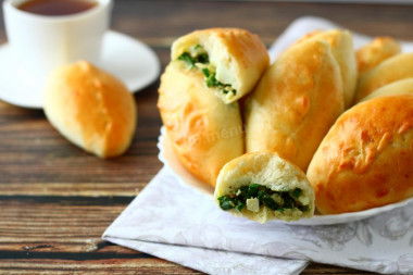 Yeast pies with green onion and egg in the oven