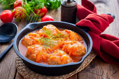 Meatballs in tomato paste with rice in a frying pan