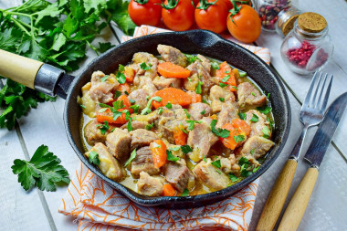 Pork with onions and carrots in a frying pan