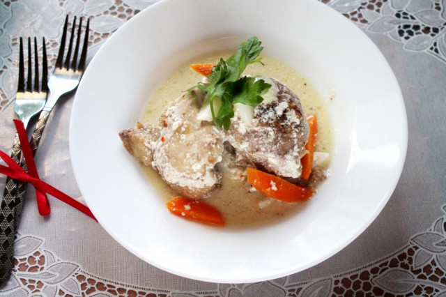 Fried chicken with garlic in a frying pan in sour cream