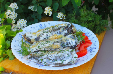 Fried crucian carp in sour cream in a frying pan