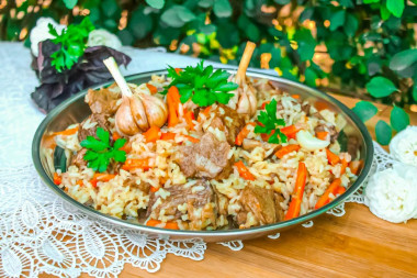 Beef pilaf in a cauldron over a campfire