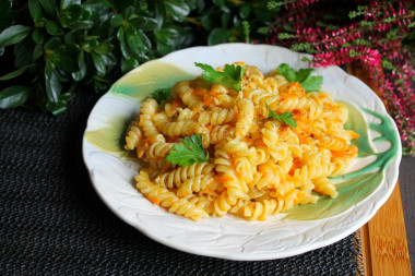 Pasta with carrots and onions in a frying pan