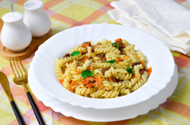 Pasta with stewed meat in a frying pan