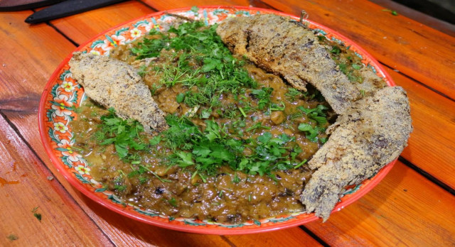 Crucian carp in sour cream sauce in a cauldron