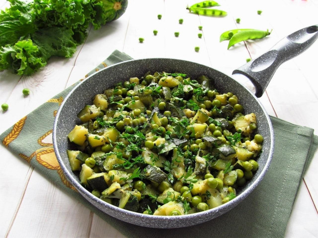 Zucchini with green peas in a frying pan