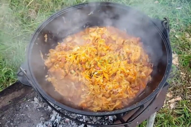 Bigus in a cauldron with smoked meats on a campfire