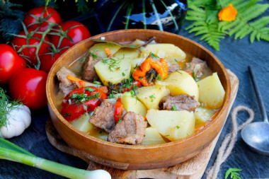 Beef and potatoes stewed in a cauldron over a campfire