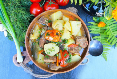 Beef and potatoes stewed in a cauldron over a campfire