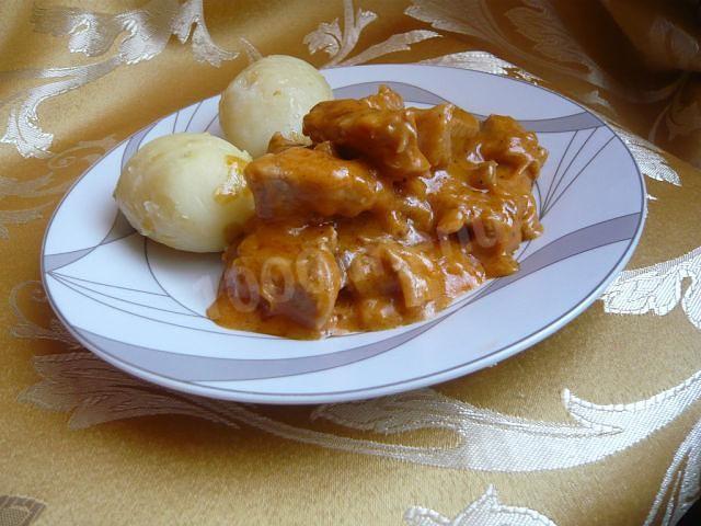 Pork goulash with sour cream, tomato paste and herbs