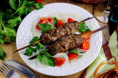 Homemade minced meat kebab in the oven on skewers