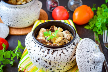 Pork meat in pots in the oven with mushrooms and cheese