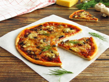 Pizza with champignons sausage and cheese in the oven