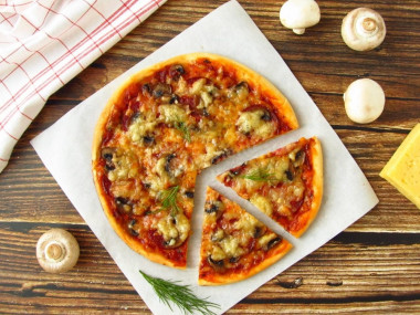 Pizza with champignons sausage and cheese in the oven