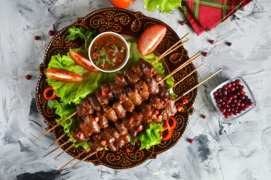 Barbecue of chicken hearts in the oven on skewers