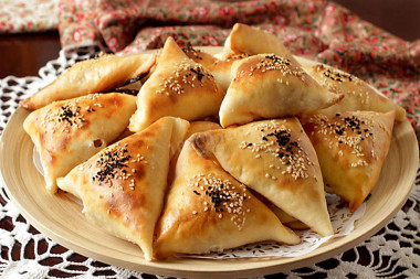 Puff pastry samsa in the oven with minced meat