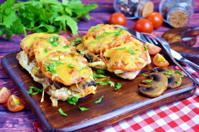 Chicken breast with mushrooms, cheese and tomatoes in the oven