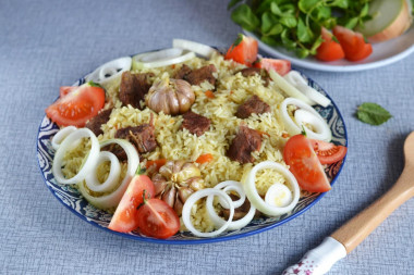 Pilaf in a cauldron of beef on the stove