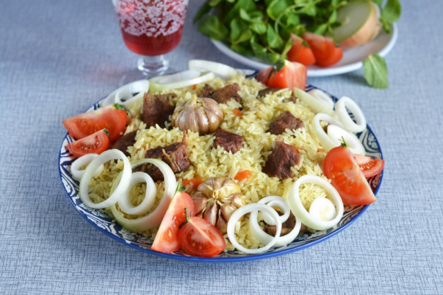 Pilaf in a cauldron of beef on the stove