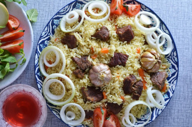 Pilaf in a cauldron of beef on the stove