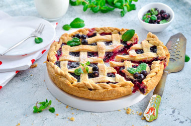 Simple shortbread pie with black currants in the oven