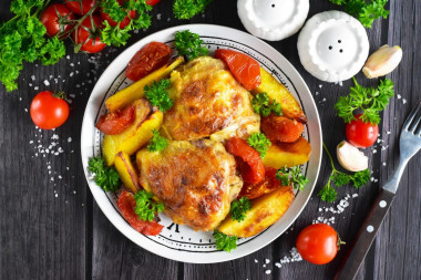 Potatoes with chicken and tomatoes in the oven