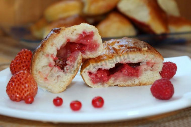 Yeast pies with berries in the oven