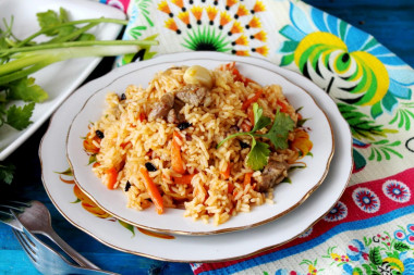 Uzbek classic pilaf with lamb in a cauldron