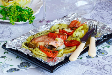 Fish in foil baked with vegetables in the oven