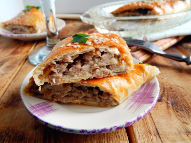 Puff pastry roll with minced meat in the oven